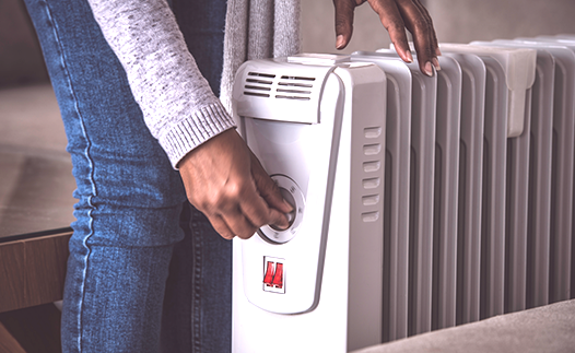 Person turning dial on portable heater