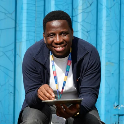 A Moat colleague sits holding a tablet in front of a blue background 