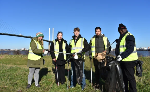 Group of people collecting rubbish with Dartford Crossing in background 2