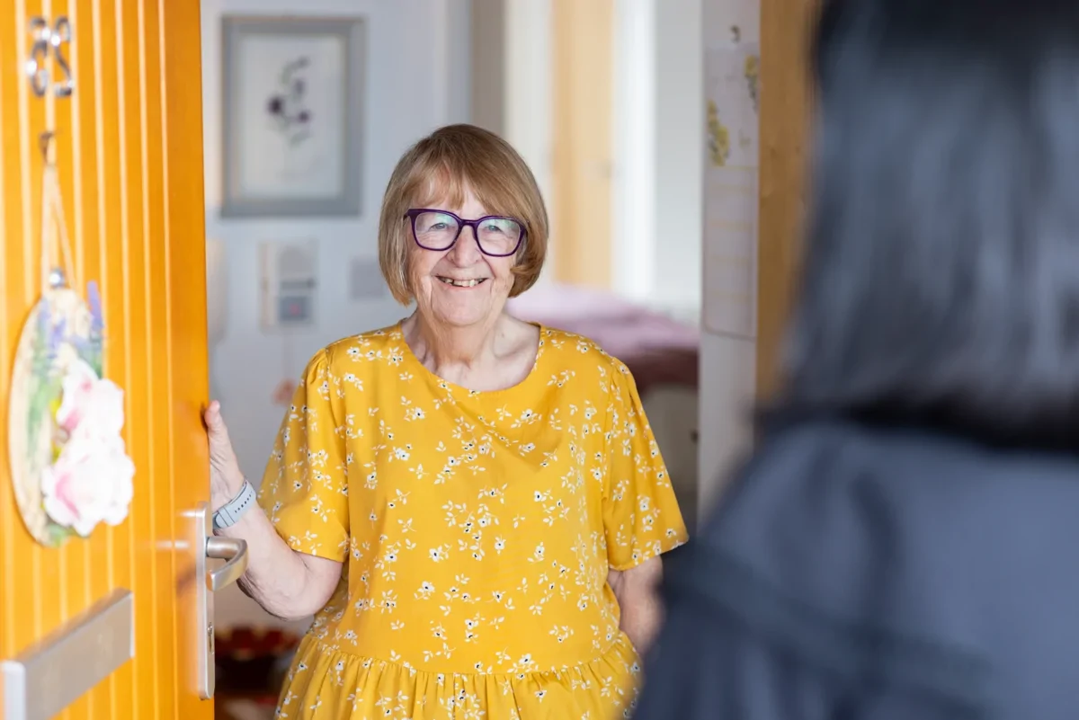 Customer at door of her home