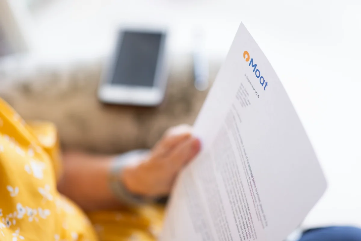 Image shows a woman reading a letter from Moat